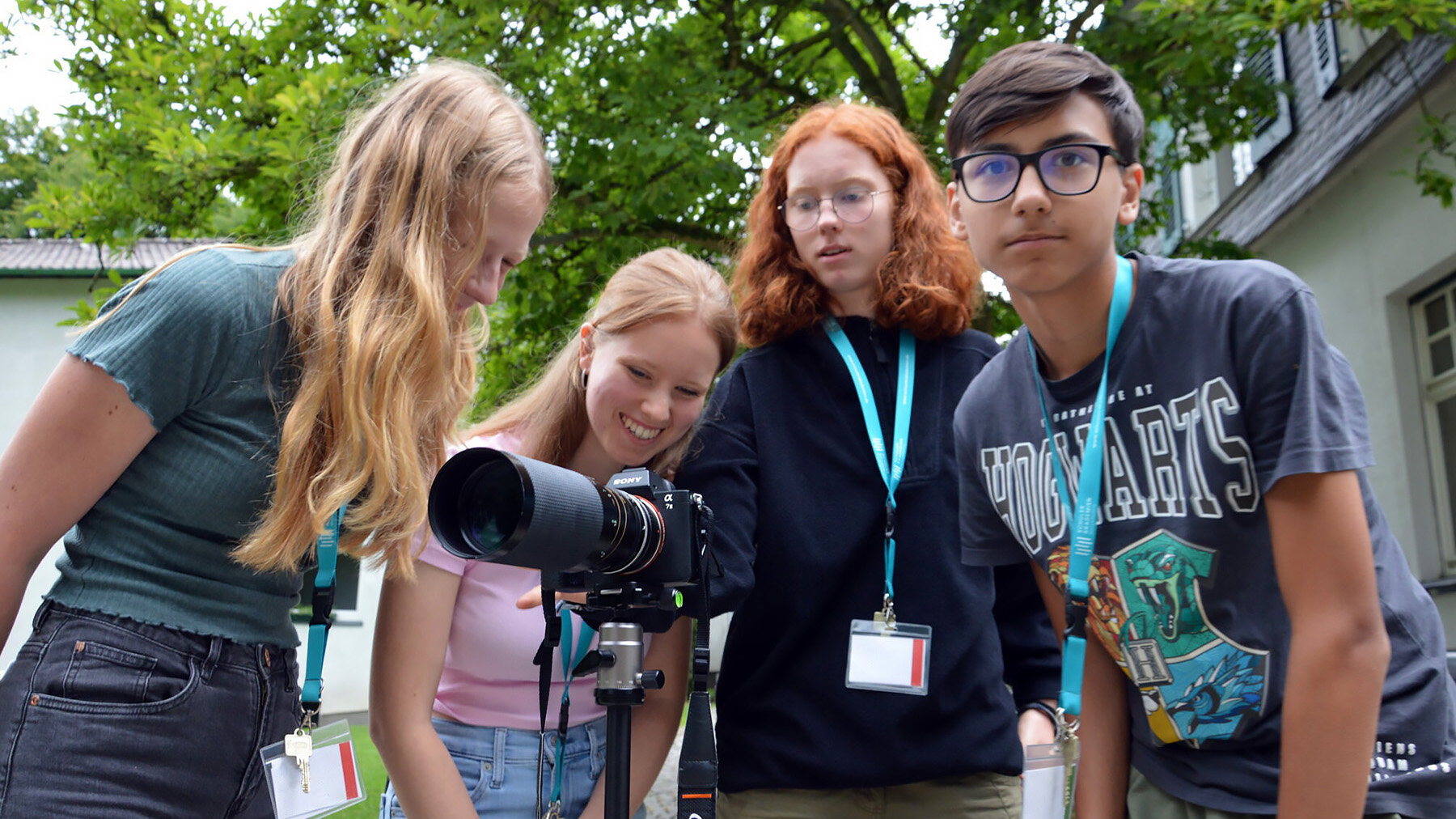 Vier Jugendliche schauen gemeinsam in eine Kamera.