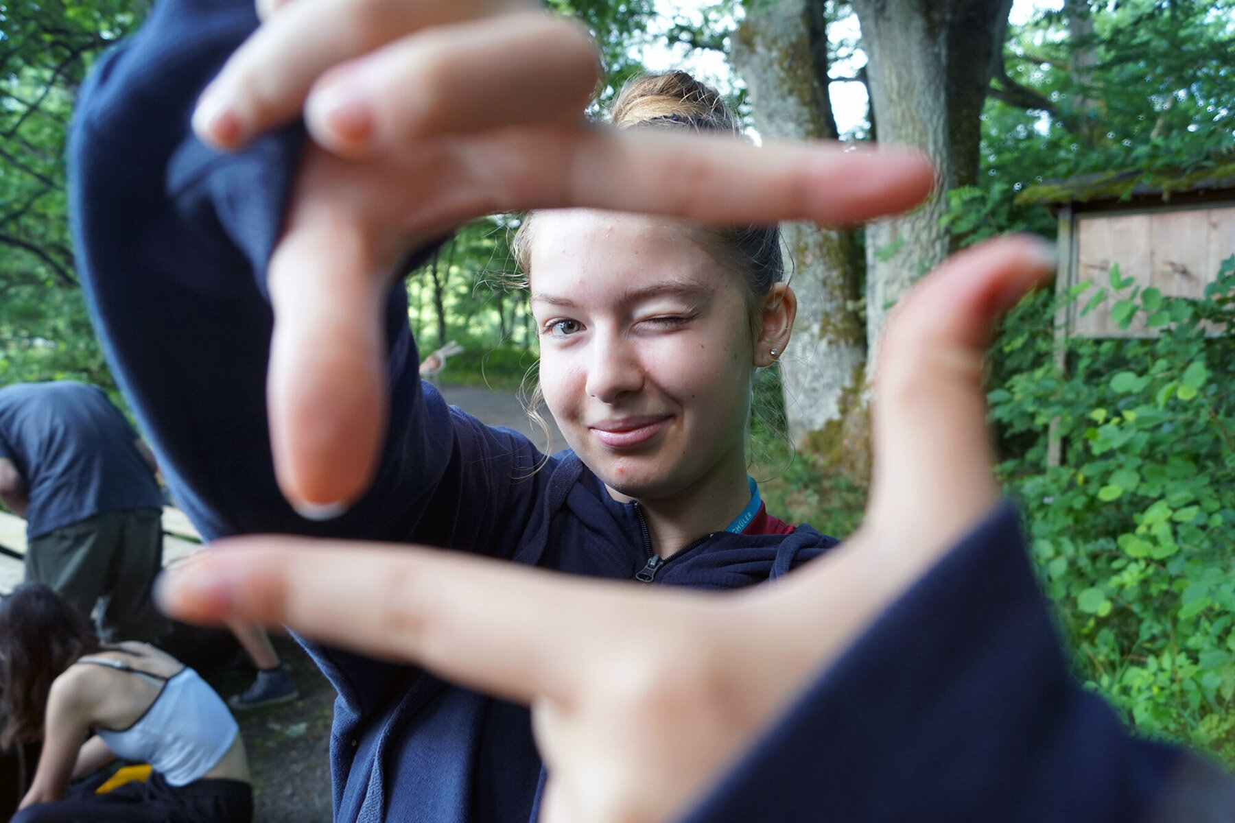 Eine Jugendliche hält ihre Hände zum Zukunftsfenster und blickt hindurch.