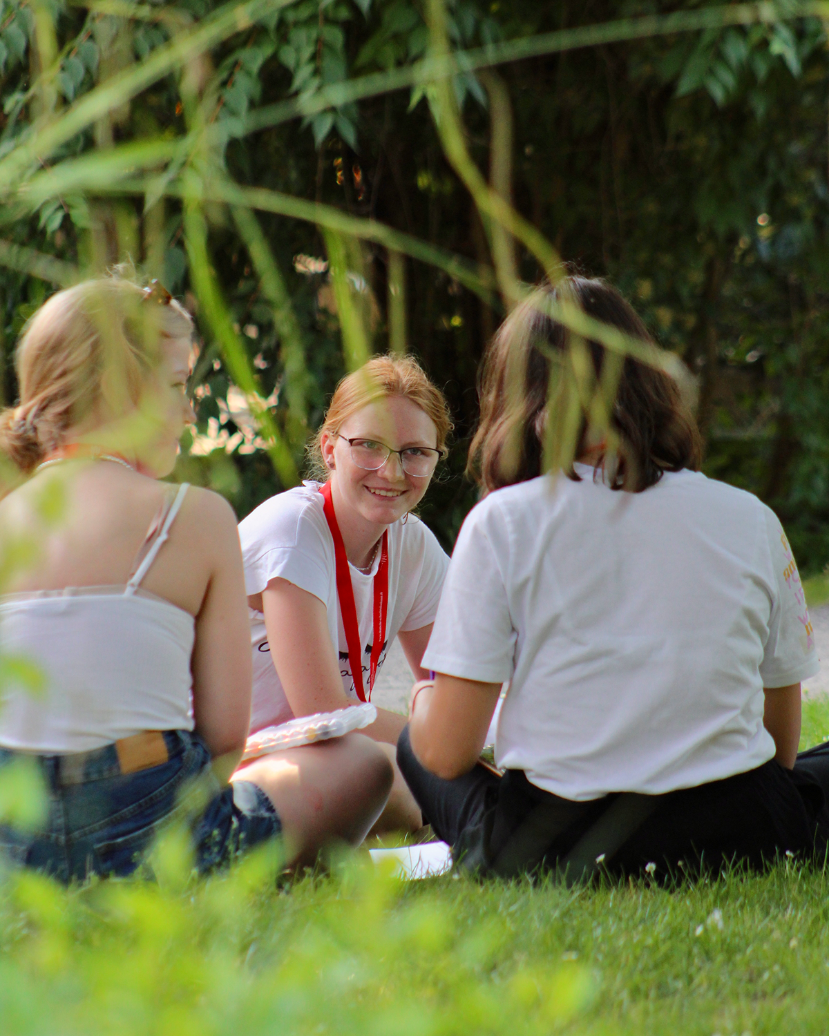 Teilnehmerinnen der Akademie Gaesdonck sitzen entspannt auf einer Wiese. 