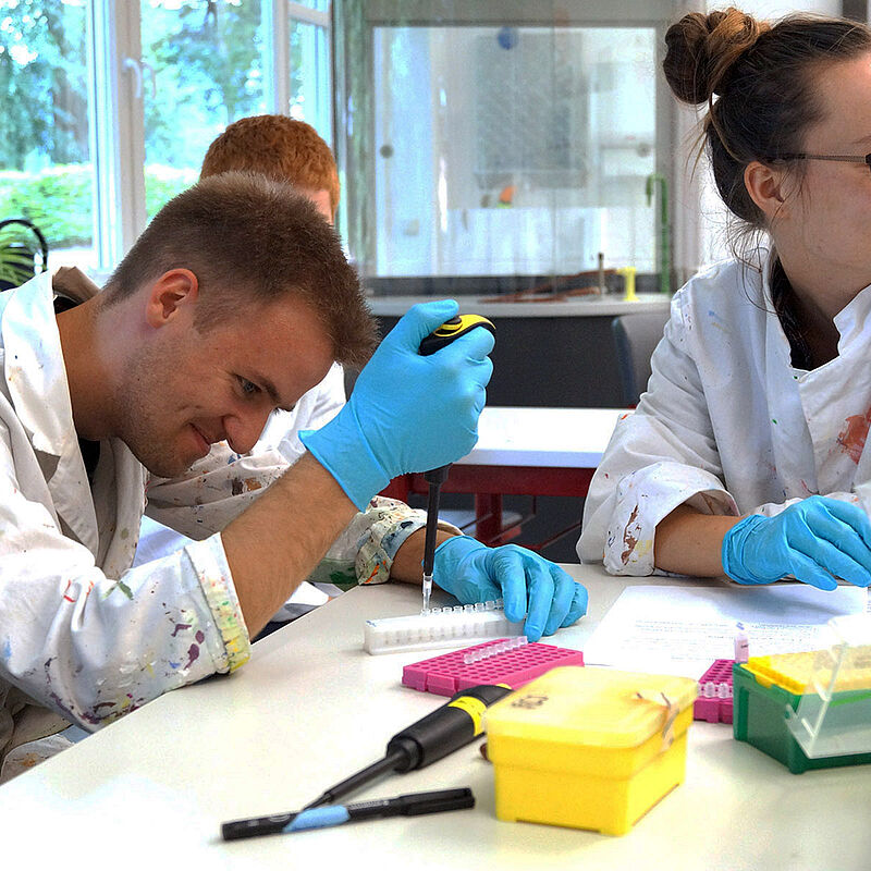 Zwei Jugendliche arbeiten gemeinsam in einem Chemie-Labor.